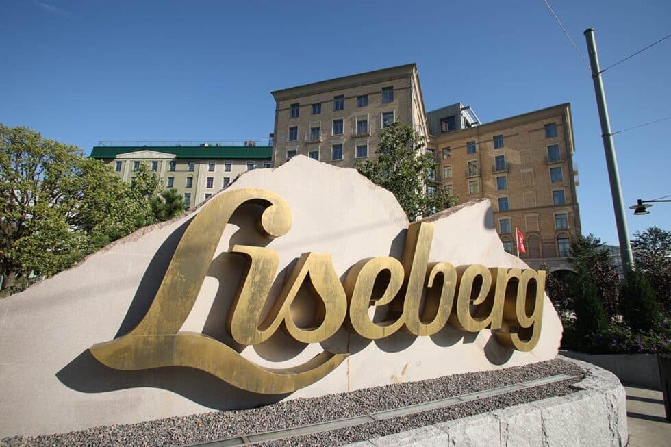 Skylt med Lisebergs logotyp i metall mot ett stenblock.